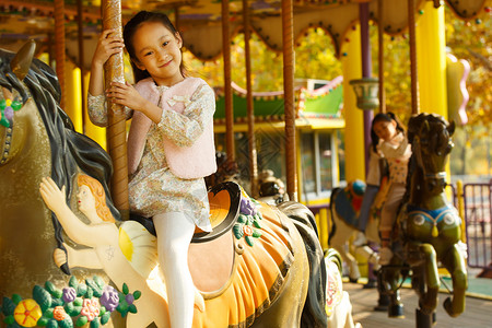 玩旋转木马的孩子水平构图放松10岁到11岁小女孩在玩旋转木马背景