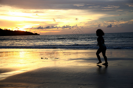 晚霞东南亚巴厘岛海滩上的孩子剪影图片