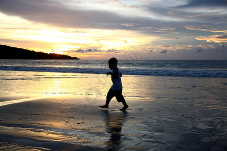 跑步金色人巴厘岛海景与孩子的剪影背景