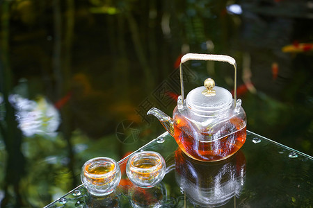 夏天池塘里的金鱼和水上的茶杯高清图片