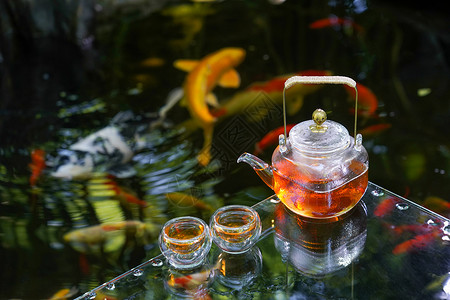 夏天池塘里的金鱼和水上的茶杯茶叶高清图片