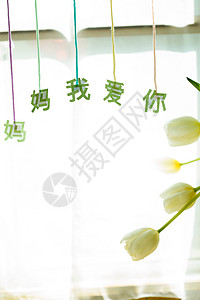 节日主题文字设计桌上的康乃馨花和信封贺卡背景