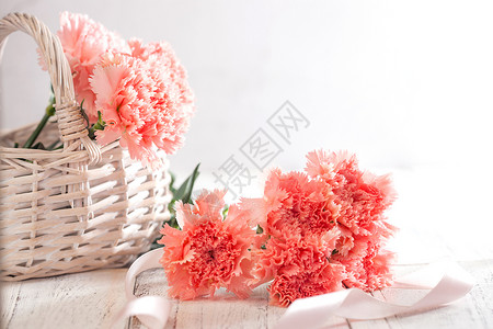 花卉装饰物桌上的康乃馨花和信封贺卡背景