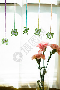 桌上的康乃馨花和信封贺卡背景图片