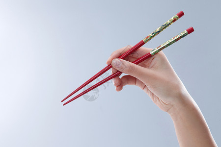 亚洲彩色图片留白手拿筷子背景图片