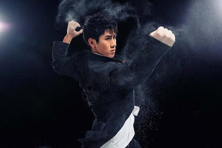 黑色烟雾冰块练习中国武术的年轻男性背景