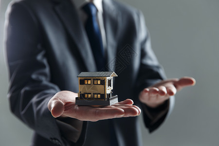 地产投资画册房地产手拿房屋模型背景