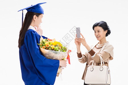 母亲用手机给毕业的女儿拍照图片