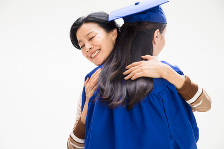 帽子和礼服和母亲拥抱的毕业大学生背景