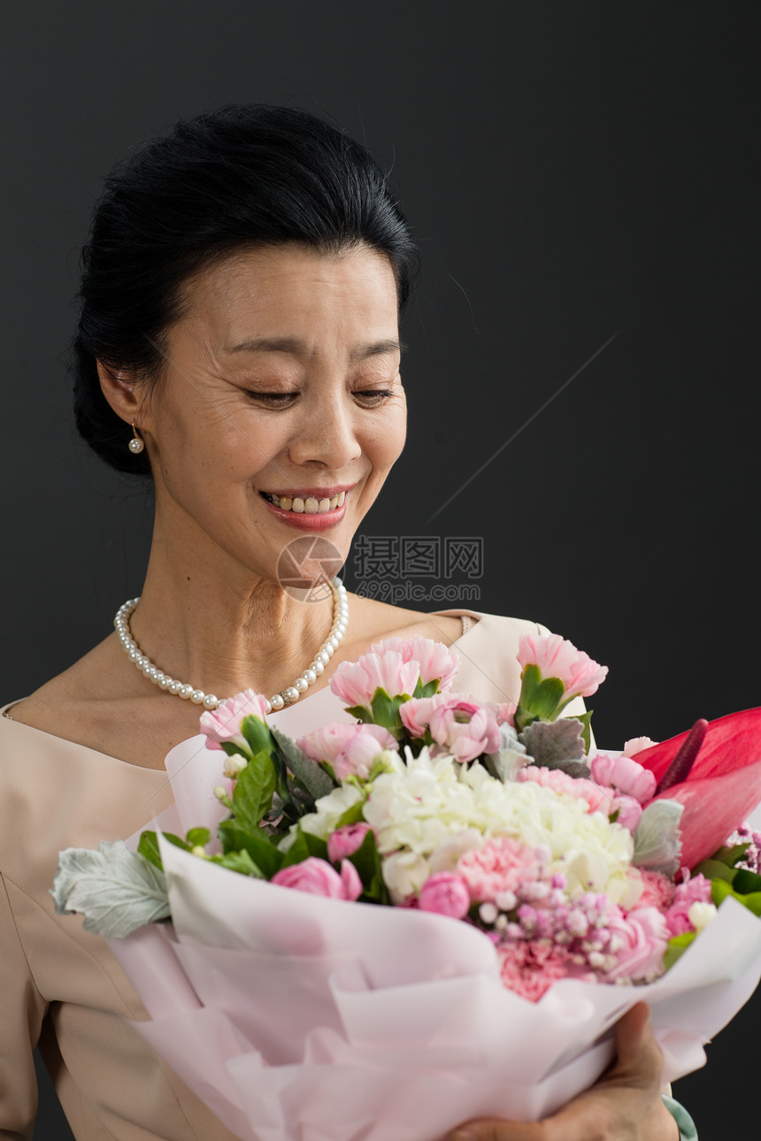 财富欢乐中老年女人手拿鲜花的优雅女士图片