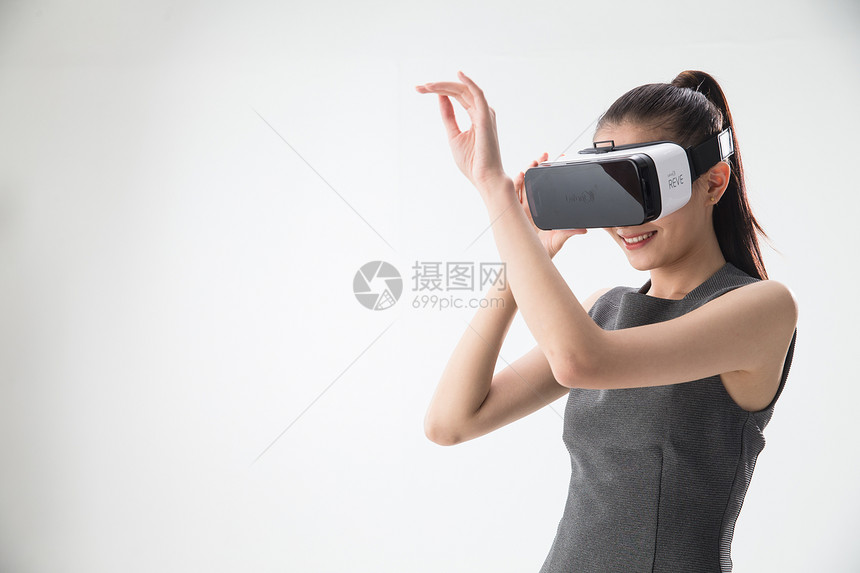 遥控器正装个戴着VR眼镜的青年女人图片