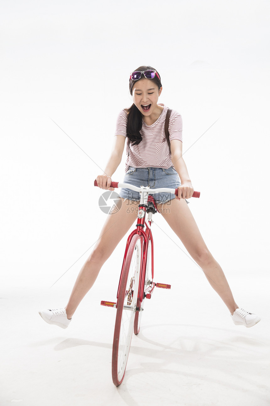 20多岁背包青年女孩骑车旅行图片