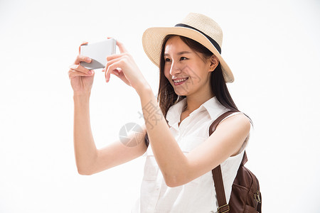 亚洲人背包快乐青年女孩用手机拍照图片