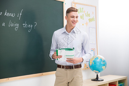 英文学校素材上课培训班仅成年人老师站在教室的黑板前背景