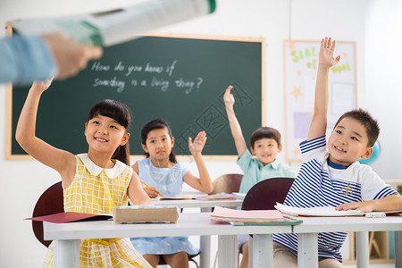 举手的小孩上课小学女生亚洲老师和小学生们在教室里背景