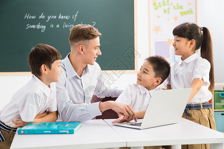 国际汉语教师休闲装户内黑板教师和小学生在教室里背景