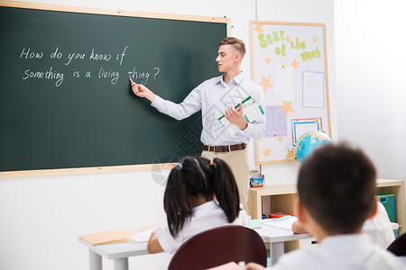 国际汉语教师好奇心国际学校快乐教师和小学生在教室里背景