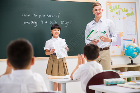 国际课堂教育业职位学习乐趣教师和小学生在教室里背景