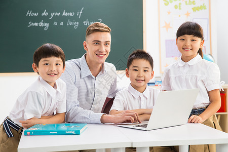 电脑未成年学生成年人教师和小学生在教室里高清图片