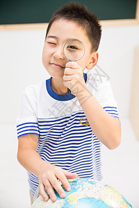 地球形状球体彩色图片垂直构图小学男生在教室里背景