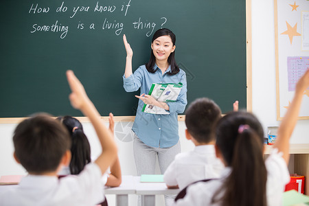 举手男孩贡献东亚教师老师和小学生们在教室里背景