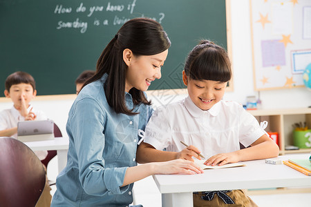 摄影课程摄影成年人写字老师和小学生们在教室里背景