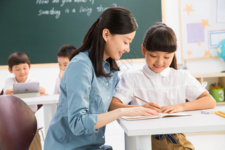 努力摄影责任老师和小学生们在教室里图片