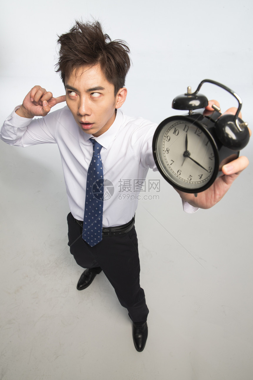成年人夸张亚洲商务青年男人拿着闹钟图片