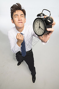 亚洲人变形压力商务青年男人拿着闹钟图片