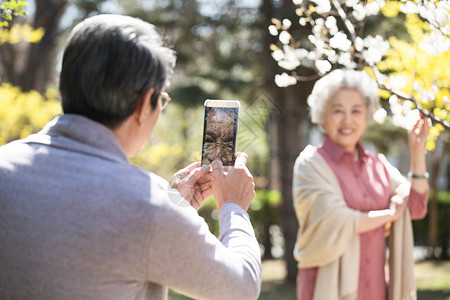 为春天上色树退休家庭生活丈夫在为妻子拍照背景