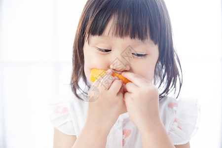 橙子表情水果可爱的小女孩在吃橙子背景