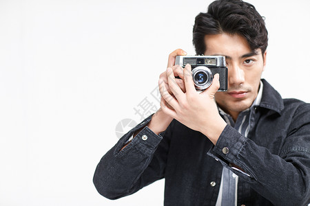 人造型影棚拍摄青年男人拿着照相机图片