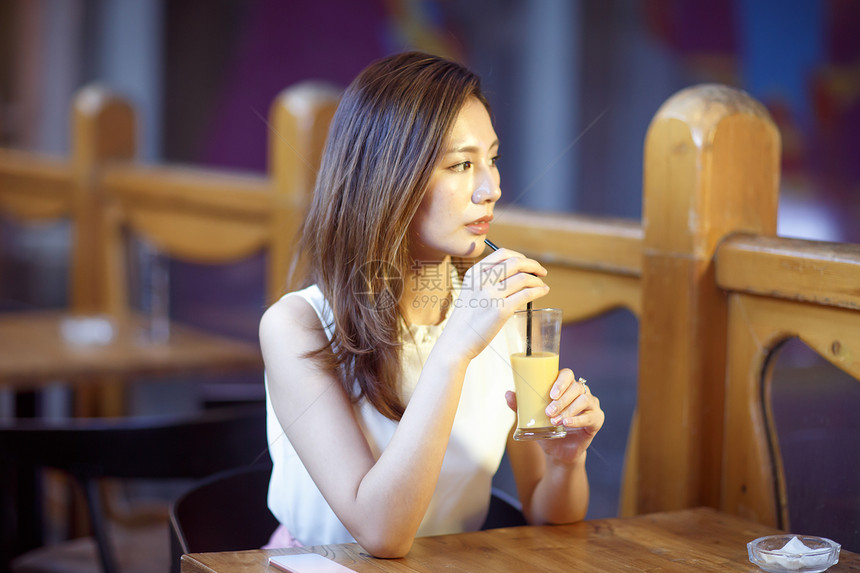 便利咖啡店青年女人在喝果汁图片
