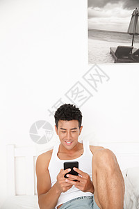 亚洲人互联网不看镜头青年男人在卧室玩手机图片
