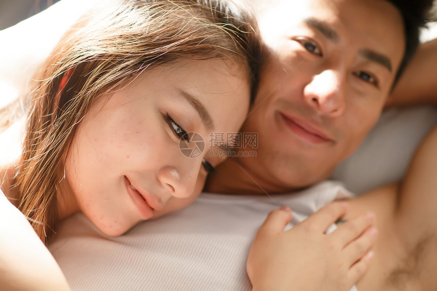 青年人放松深情的青年情侣在床上图片