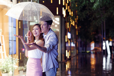 打伞约会的情侣雨天情侣一起逛街背景