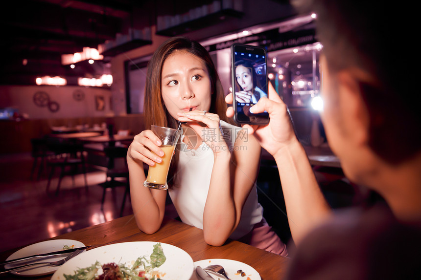 北京休闲活动微笑青年情侣吃晚餐图片