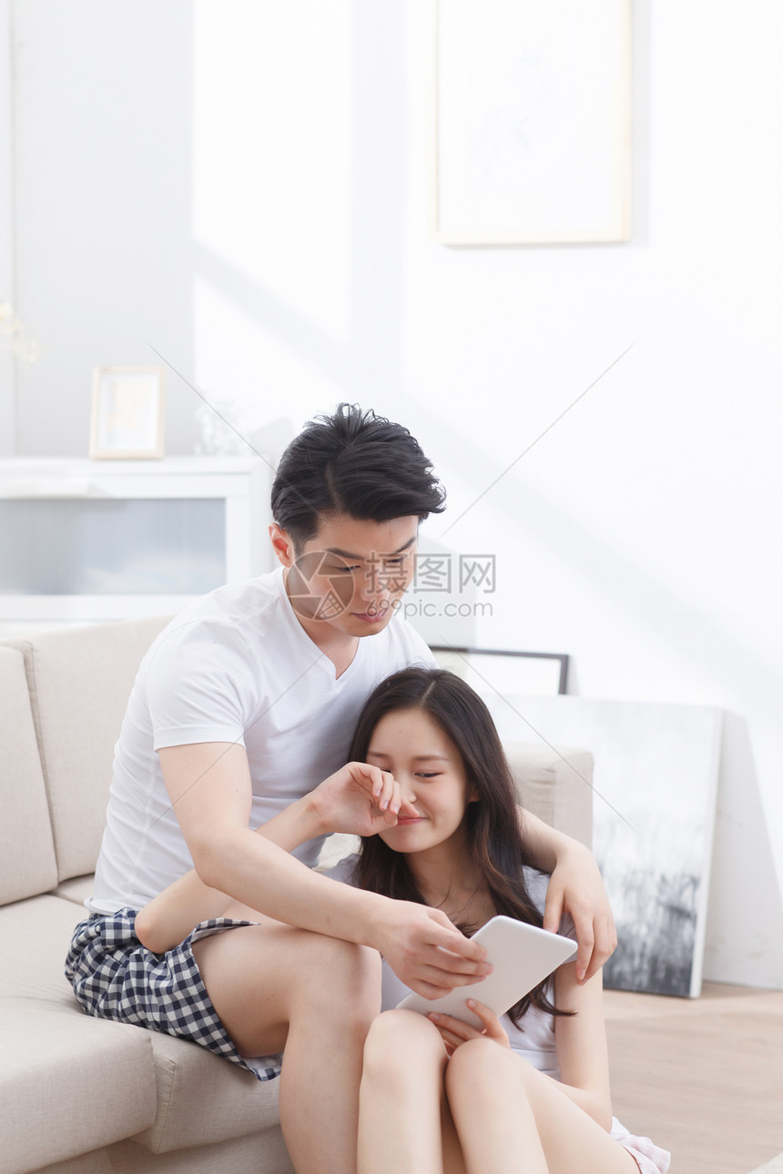 东亚拿着坠入爱河青年情侣看平板电脑图片