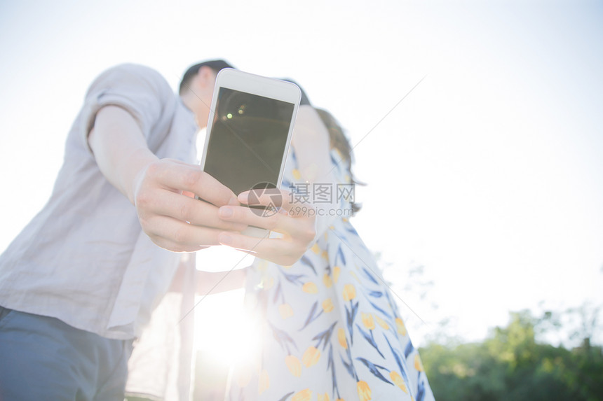 白昼非都市风光面部表情青年情侣用手机照相图片