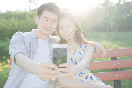 25岁到29岁高兴的彩色图片青年情侣用手机照相图片