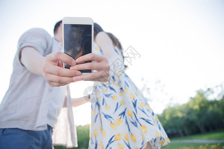 遮挡青年伴侣城市生活青年情侣用手机照相图片