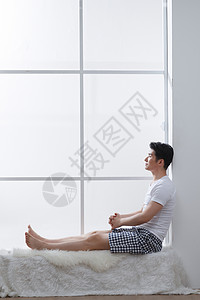 家庭生活住宅内部侧面视角青年男人坐在窗户旁边图片