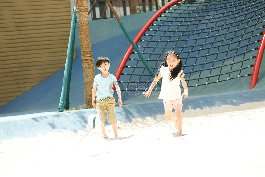 休闲装童年玩耍儿童在沙子里踢球图片