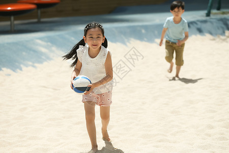 游乐场儿童在沙子里踢球图片
