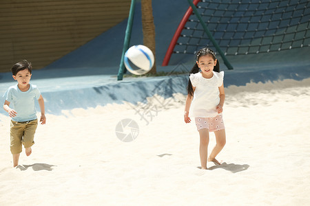 儿童在沙子里踢球图片