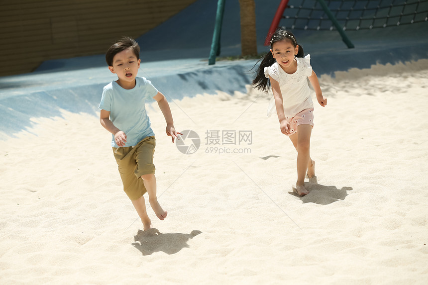 快乐儿童在沙子里踢球图片