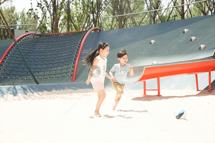 高兴休闲活动童年儿童在沙子里踢球图片
