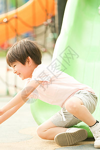高兴休闲装游乐场小男孩在户外玩滑梯图片