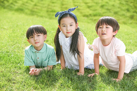 童年三个人玩耍快乐的孩子趴在草地上图片