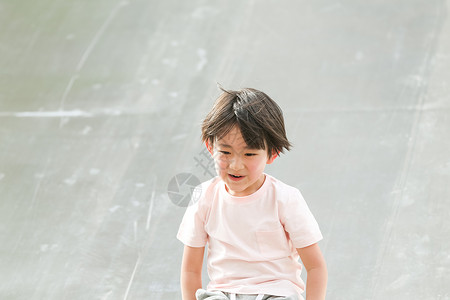 幸福不看镜头休闲活动小男孩在户外玩滑梯图片
